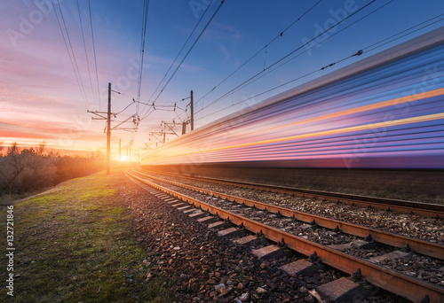 Fotografia High speed passenger train in motion on railroad at sunset