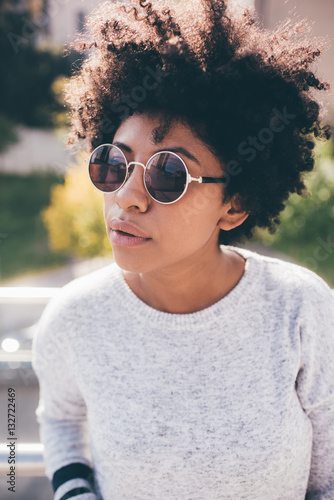 Portrait of young beautiful afro woman outdoor in the city back light having fun - carefree, serene, thoughtless concept