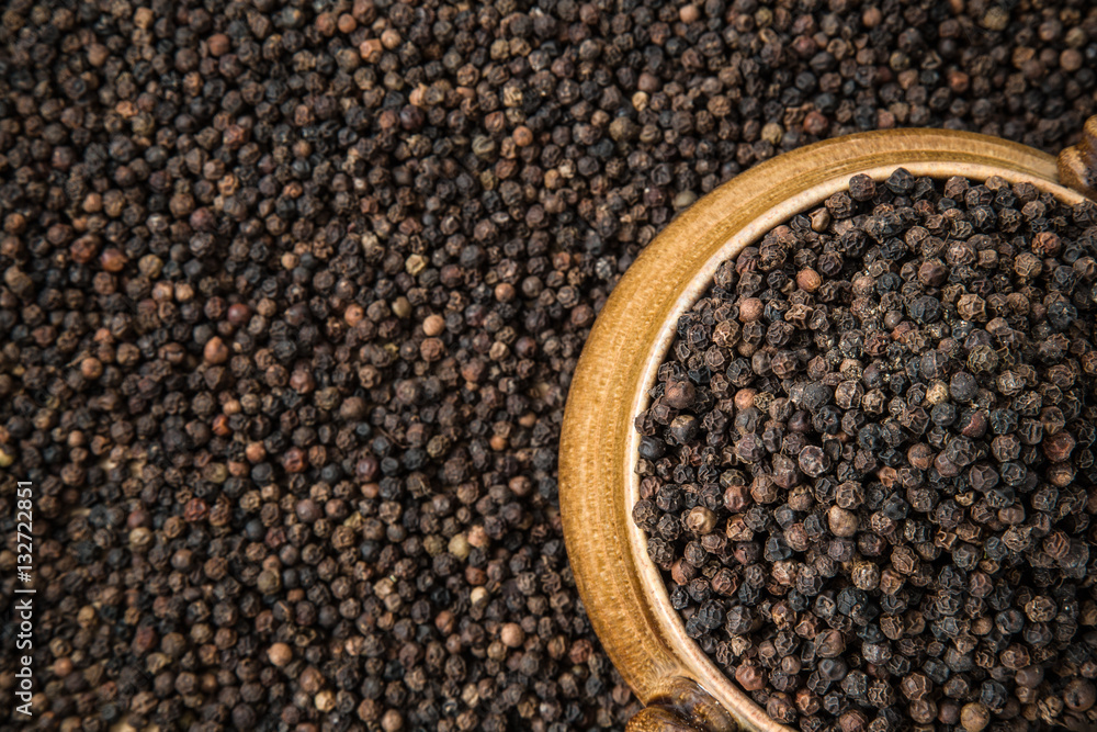 Black pepper grain in the bowl on the pepper background. Healthy eating and lifestyle. Black pepper grain in the bowl on the pepper background. Healthy eating and lifestyle.
