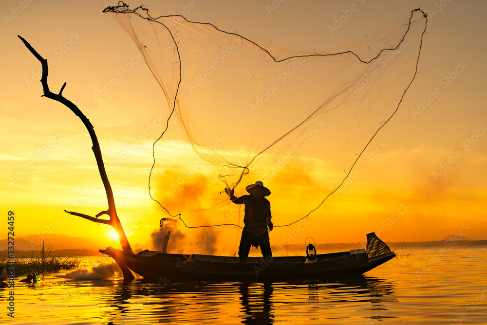 fisherman throwing net catching fish in the lake Stock Photo