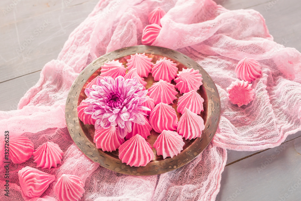 Air meringue with fresh flowers are on a pink napkin Air meringue with fresh flowers are on a pink napkin