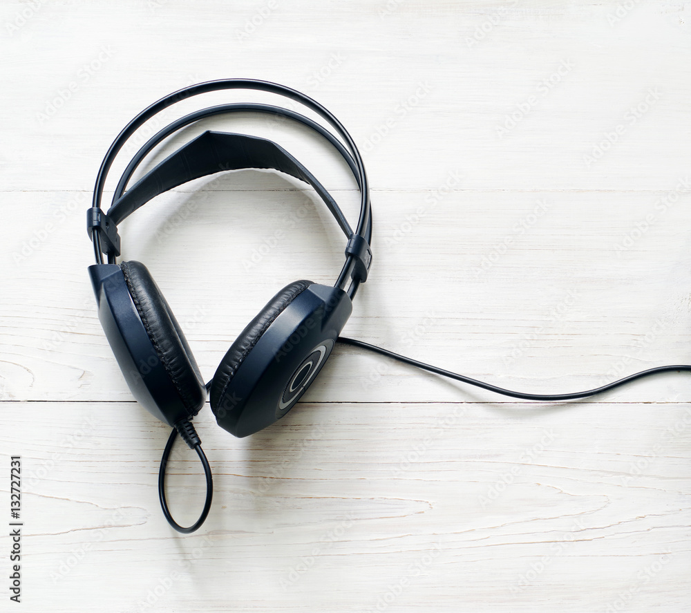 Black headphones on a white wooden background Black headphones on a white wooden background
