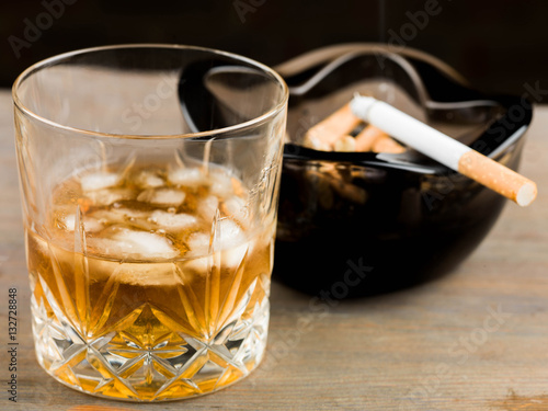 Glass of Scotch Whiskey and a Cigarette in an Ashtray photo