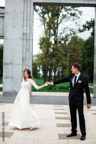 happy bride and groom at a park on their wedding day © dashamuller