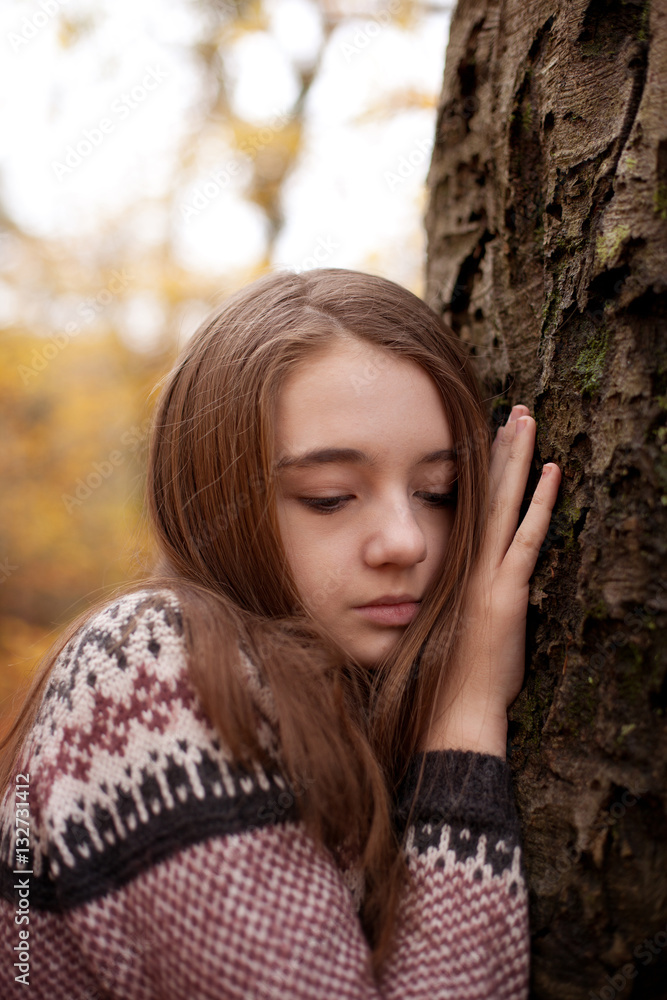 Pretty young girl leaning hand against a tree Pretty young girl leaning hand against a tree