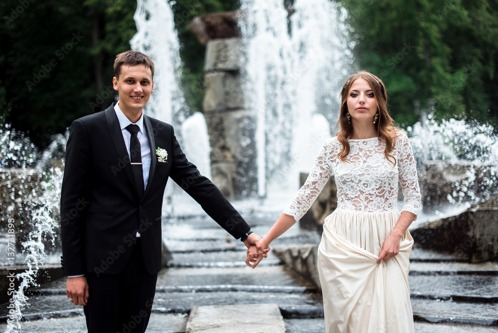 Bride and groom kissing with the fountain on the background Bride and groom kissing with the fountain on the background