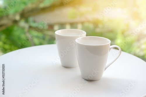 Two cup, tea or coffee on table garden bright background