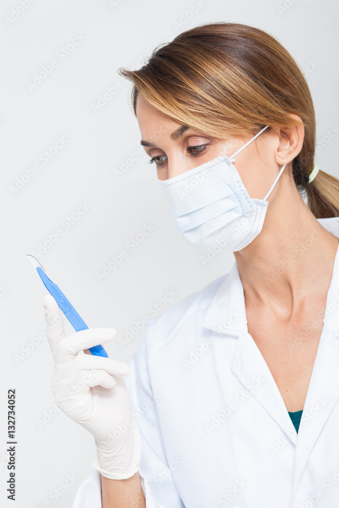 portrait de femme en blouse blanche avec un masque chirurgical et un  bistouri Stock Photo
