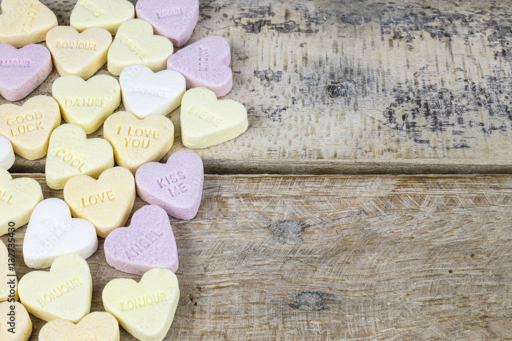 Obraz premium Group of sweet candies with heart shape on a wooden table