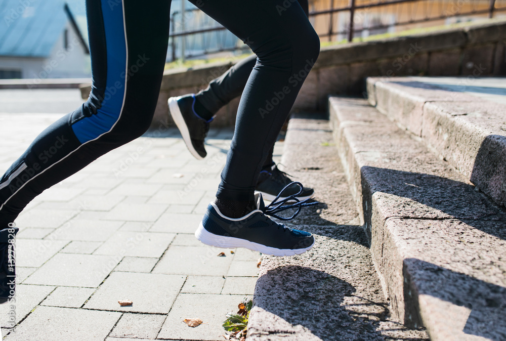 Unrecognizable athletes running on stairs on sunny autumn day. Unrecognizable athletes running on stairs on sunny autumn day.