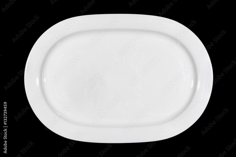Flat white shallow porcelain oval plate with shoulders on wooden cutting board directly from above Flat white shallow porcelain oval plate with shoulders on wooden cutting board directly from above