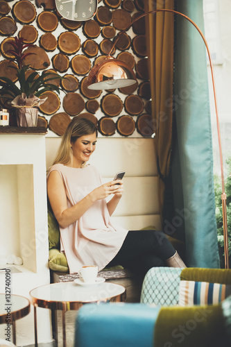 Woman sitting in cafe and u...