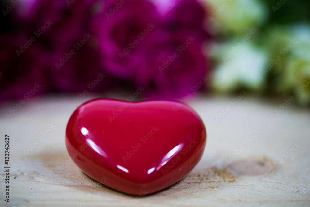 Fototapeta premium Rotes Herz mit Rosen im Hintergrund