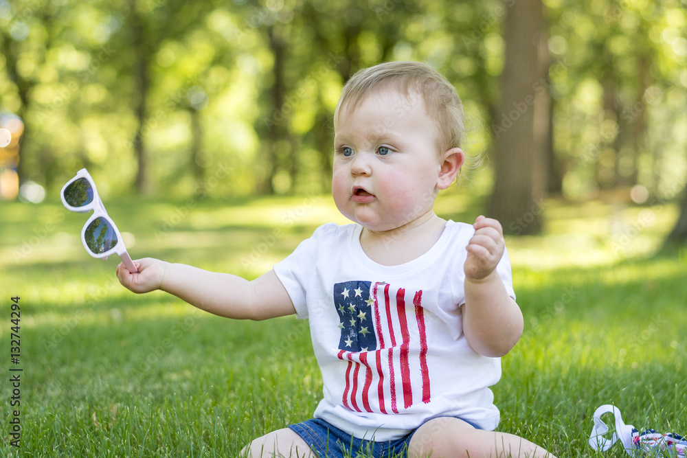 Festive one year old girl in the park on the 4th of July