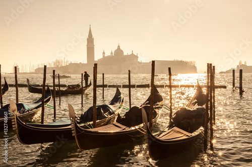 Retro effect filtered hipster style image of Gondolas on Grand canal in Venice, Italy. Beautiful summer landscape at sunset. © natalia