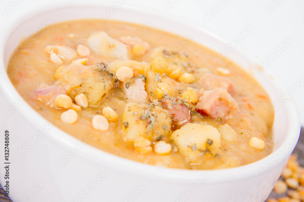 Split pea soup, decorated with some bay leaves, marjoram and peas