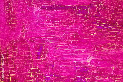 Cracked pink paint on the yellow surface