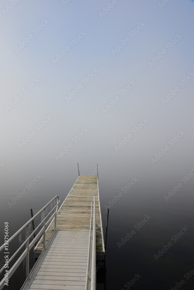 Obraz premium boat dock vanishing in lake with heavy fog