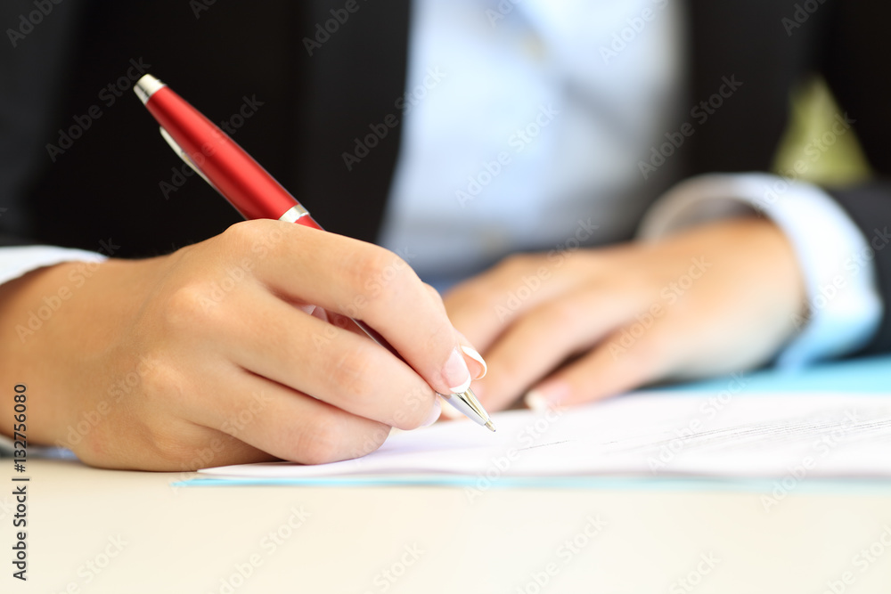 Businesswoman hands writing in a document Businesswoman hands writing in a document
