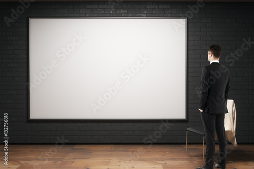 Man looking at empty billboard