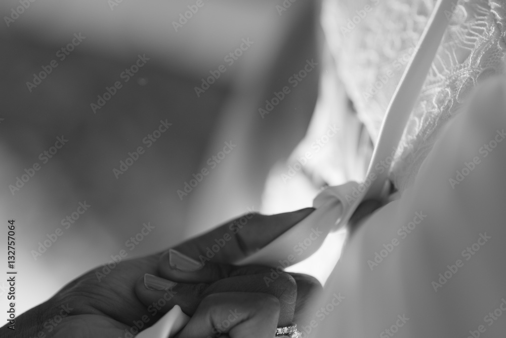 bride putting on wedding dress close up