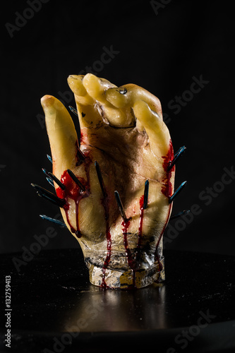 wax hand sculpture with nails and blood