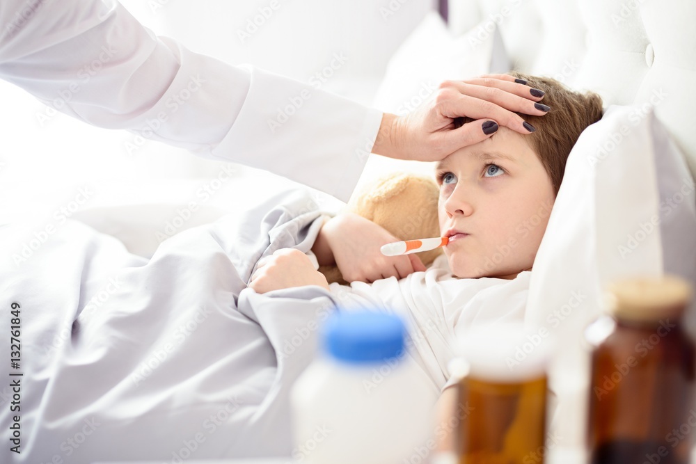 Naklejka premium Sick little child with temperature in bed.