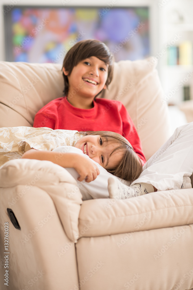 Child inside interior of modern home sitting on sofa Child inside interior of modern home sitting on sofa