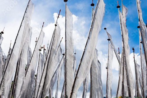 Фотография Bhutan white prayer flags in the wind with religious text on it