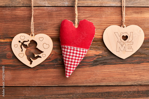 Fabric and wooden hearts. Cut-out Cupid on wooden background. Celebration of love.