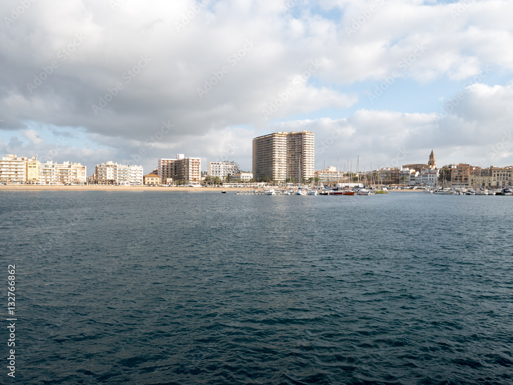 Widok na plażę i port w Palamós, zachmurzone niebo, morze Śródziemne, Hiszpania Widok na plażę i port w Palamós, zachmurzone niebo, morze Śródziemne, Hiszpania