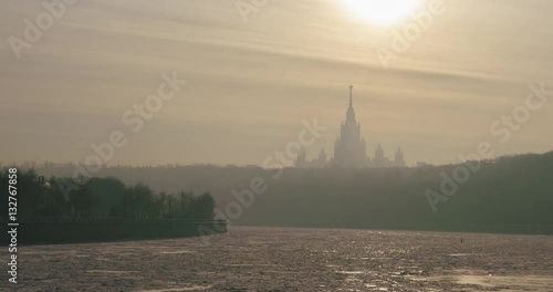 Frozen Moscow river and building of Moscow State University in the rays of the winter sun time-lapse