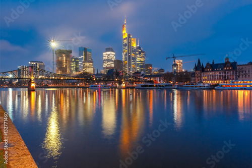 Picturesque view of Frankfurt am Main skyline and Eiserner Steg bridge with mirror reflections in the river during morning blue hour  Germany
