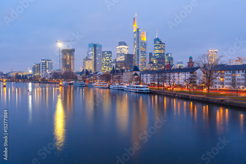Picturesque view of business district with skyscrapers and Old Town witn mirror reflections in the river during morning blue hour, Frankfurt am Main, Germany