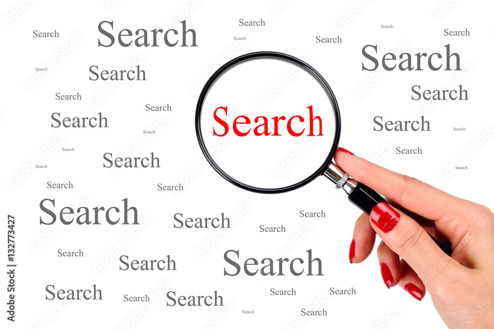 Woman's hand with red nail polish holding a magnifying glass over the word search Woman's hand with red nail polish holding a magnifying glass over the word search