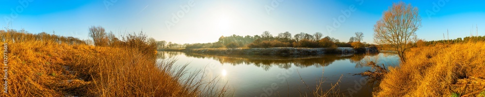 Herbstliche Landschaft mit Fluss bei strahlendem Sonnenschein