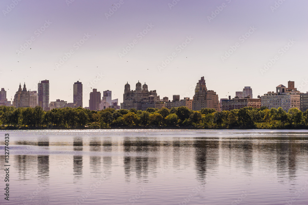 New York City skyline with skyscrapers visible from Central Park, over the reservoir.