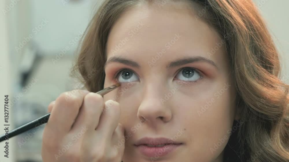 Professional makeup for the brown-haired model at the beauty salon Professional makeup for the brown-haired model at the beauty salon
