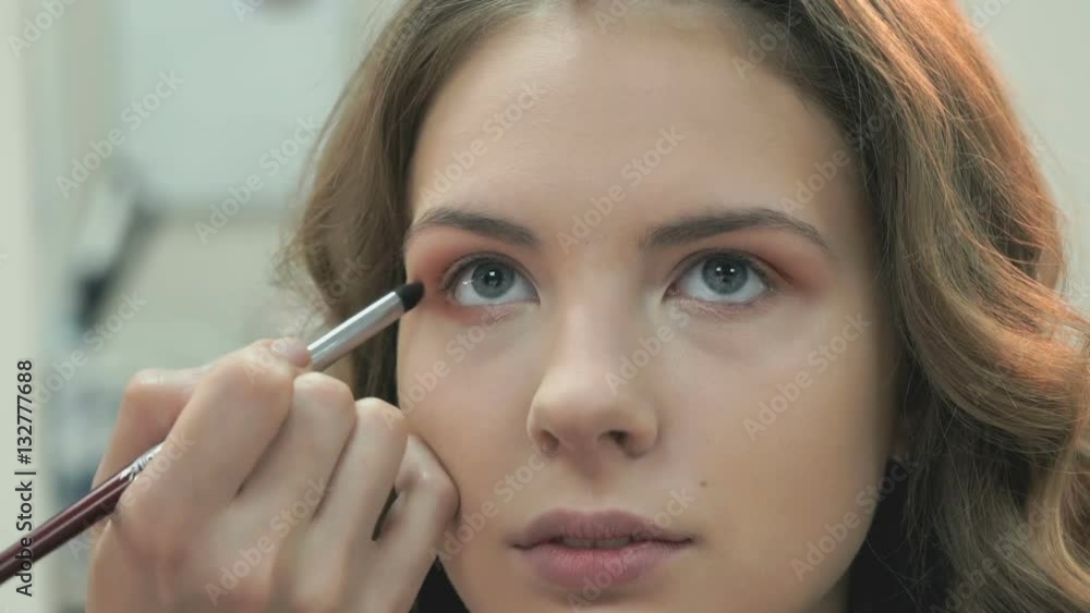 Making of professional make-up for young beautiful girl by make-up artist at the beauty salon Making of professional make-up for young beautiful girl by make-up artist at the beauty salon