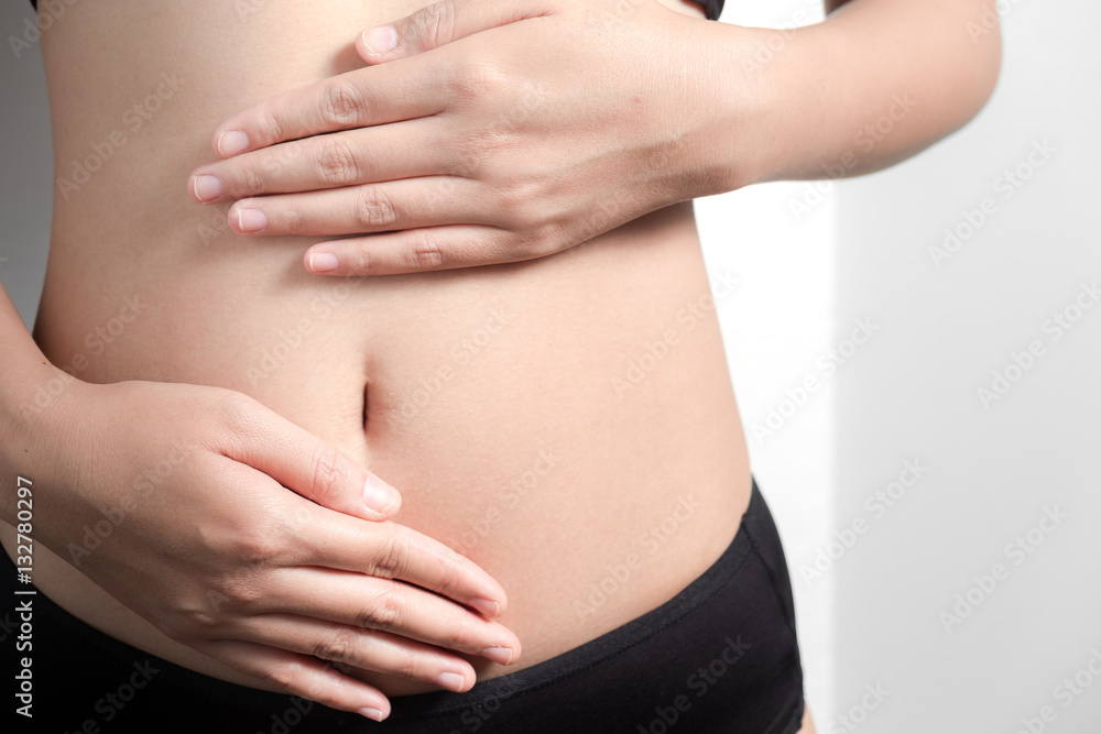 Pregnancy or diet concept, female hands protecting the stomach on white background. Pregnancy or diet concept, female hands protecting the stomach on white background.