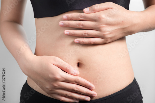 Pregnancy or diet concept, female hands protecting the stomach on white background.