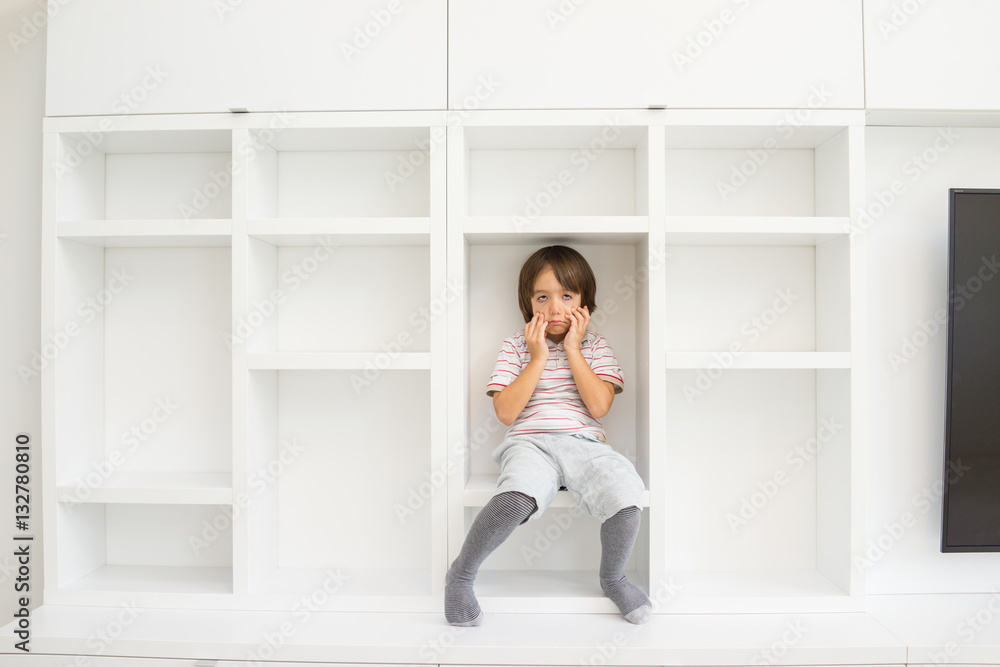 Child in shelf inside living room