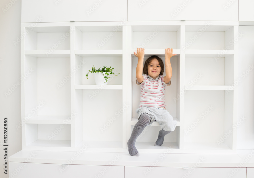 Kid in shelves at home Kid in shelves at home