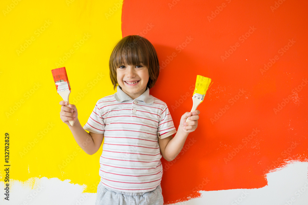Child painting the home wall in colors Child painting the home wall in colors