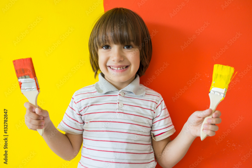 Child painting the home wall in colors Child painting the home wall in colors