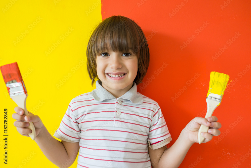 Child painting the home wall in colors Child painting the home wall in colors