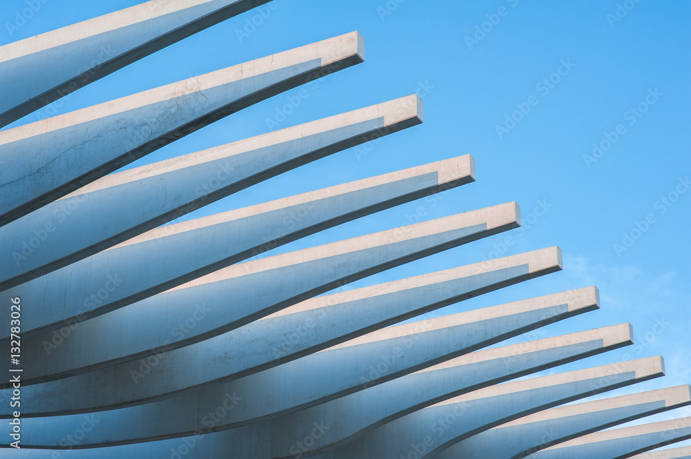 Obraz premium Modern stone promenade roof architecture by the shoreline of Palmeral de las sorpresas port in Malaga, Andalusia, Spain, Blue sky at sunset.