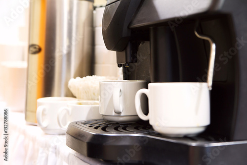 Fresh coffee prepared in the coffee machine. Espresso in white c