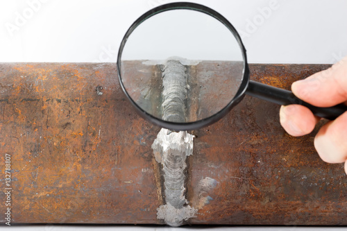 Visual inspections of the weld pipe with a magnifying glass photo