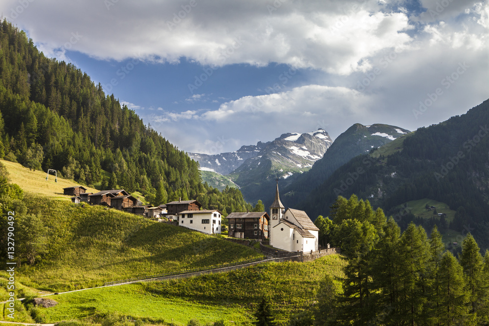 idyllic swiss mountain village with church in alps in switzerland Foto,  Poster, Wandbilder bei EuroPosters